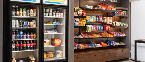 A snack and beverage display area with refrigerated cases and shelves stocked with various products.