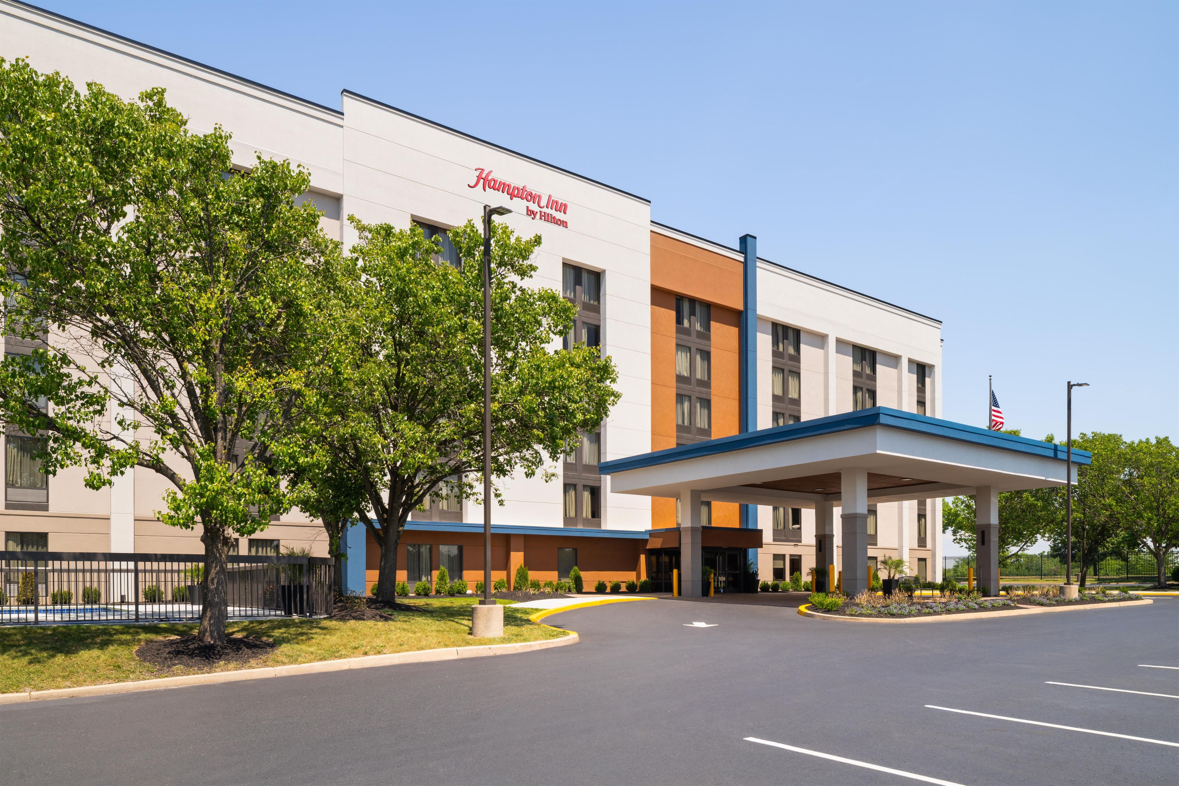 Un hotel Hampton Inn by Hilton con vestíbulo techado y estacionamiento.