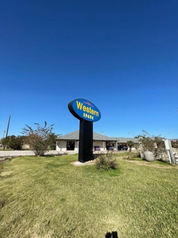 A Western Inn sign with a clear blue sky in the background. - WESTERN INN (West Columbia)