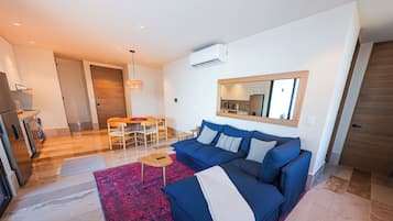Departamento Confort, vista al océano | Área de sala de estar | Televisión de pantalla plana de 50 pulgadas con canales digitales