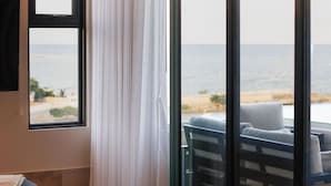 A room with a large sliding glass door leading to a balcony with a view of the beach. - Distrito Puerto - Ocean & Mangrove Views (Puerto Morelos)