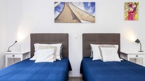 Een hotelkamer met twee bedden, elk voorzien van een hoofdeinde en nachtkastjes.
