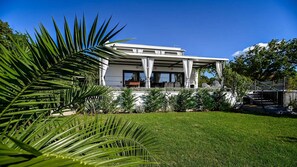 A modern two-story house with a covered patio area.