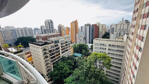 Zona urbana con rascacielos y varios edificios, incluyendo una estructura beige destacada con balcones y un jardín en la azotea.