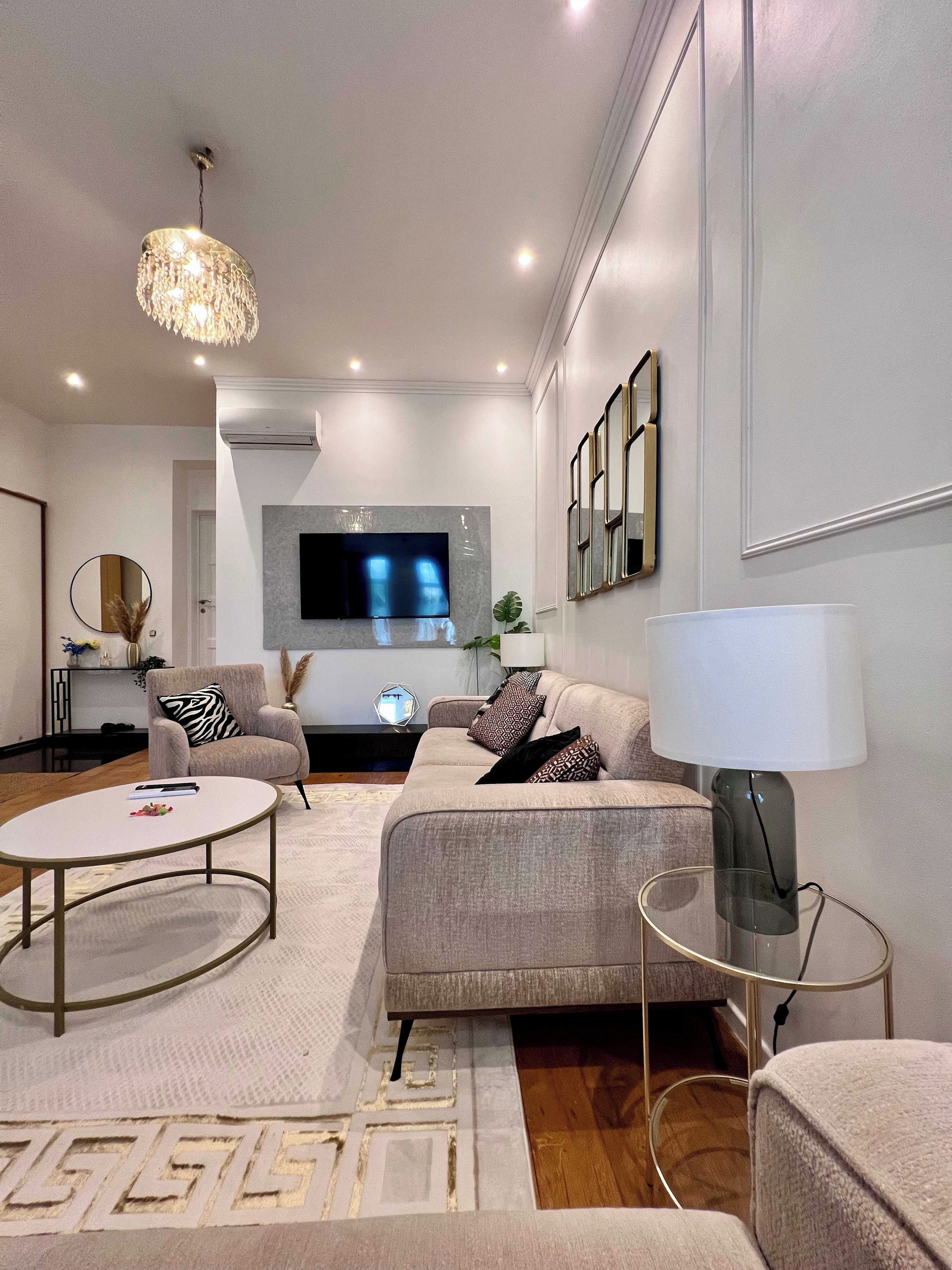 Un salon moderne avec un canapé, une table basse et un téléviseur fixé au mur.