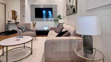 Un salon moderne avec un canapé, une table basse et un téléviseur fixé au mur.
