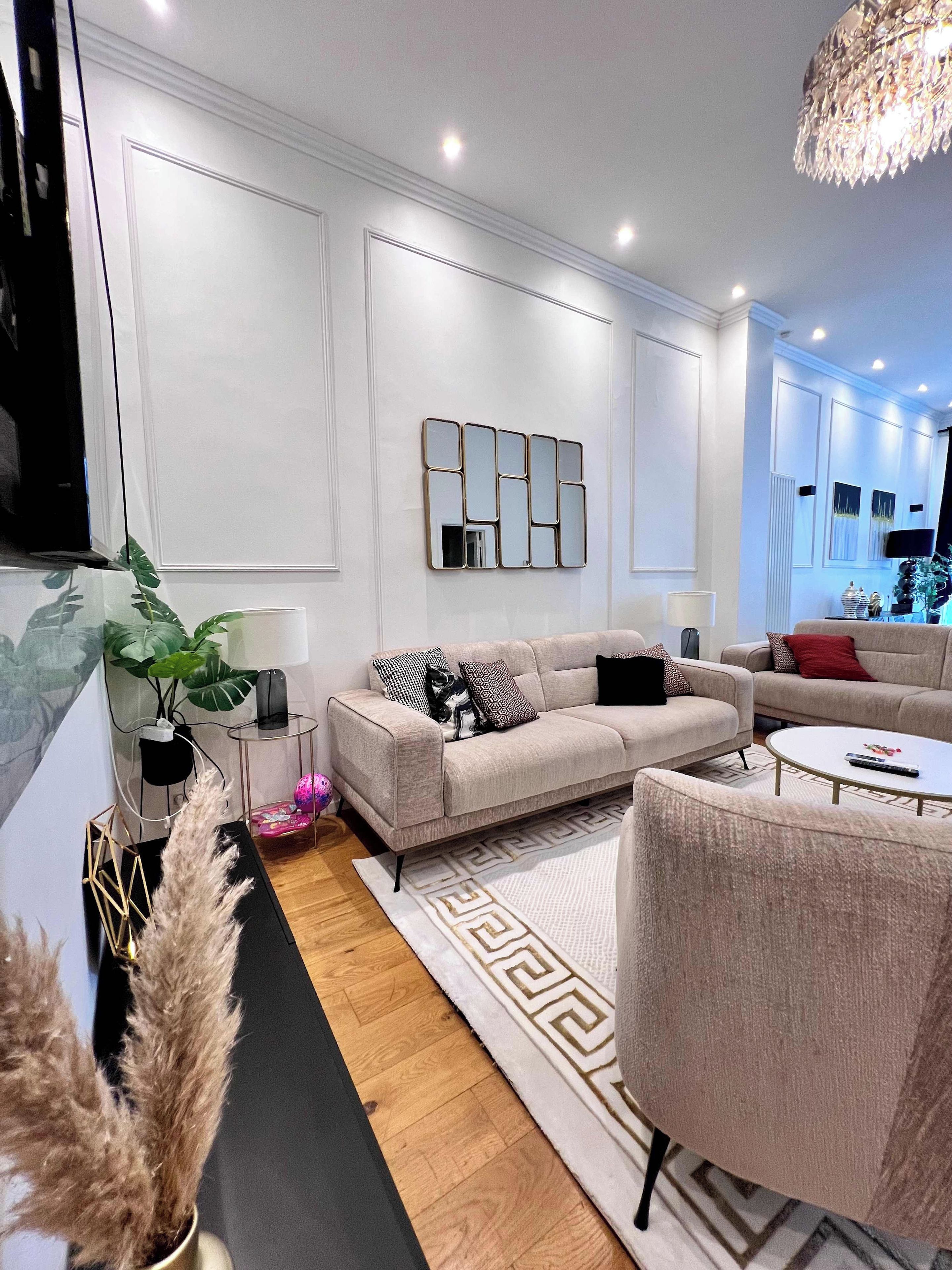 Un salon moderne avec un canapé, une table basse et des miroirs décoratifs.