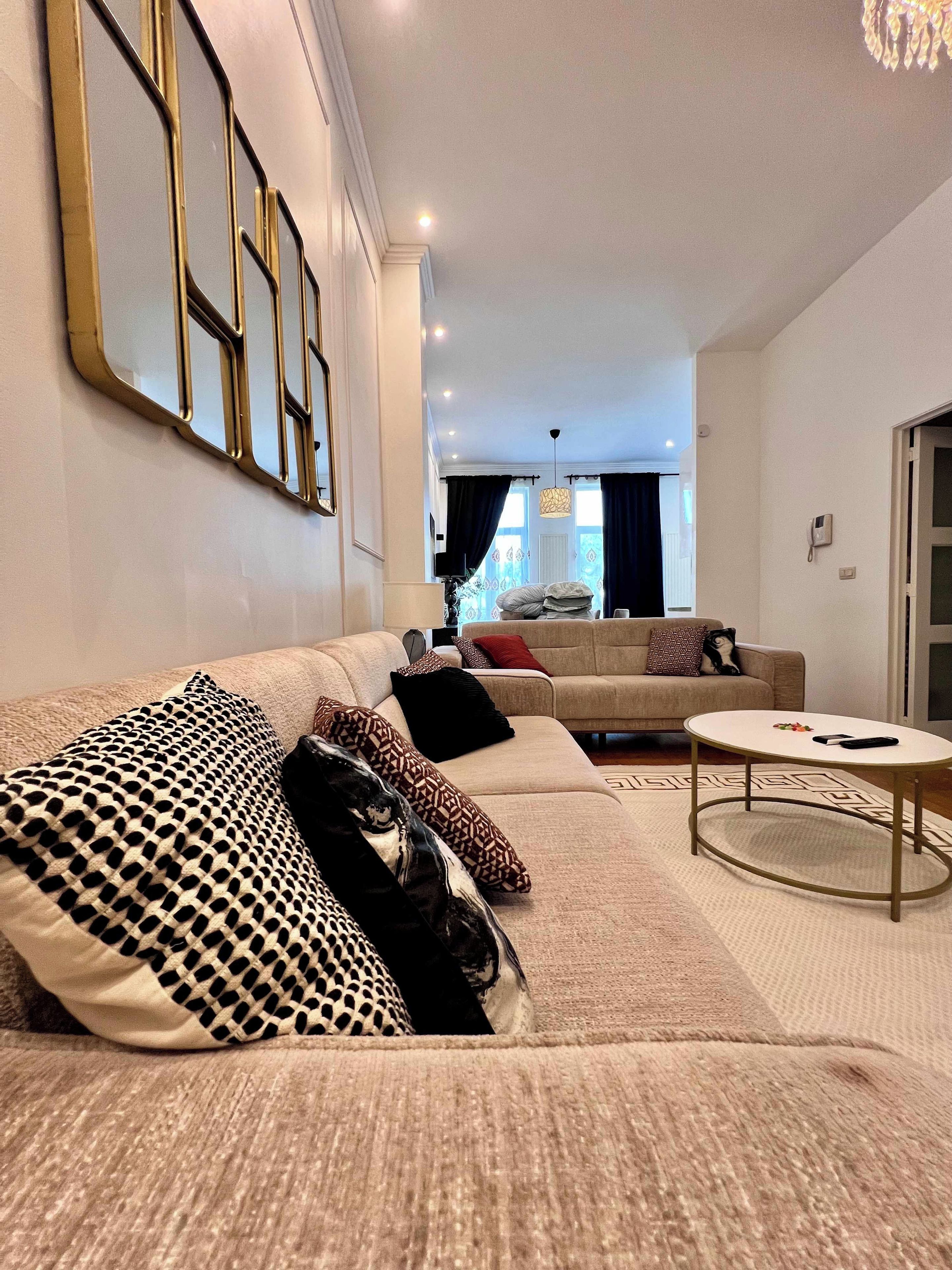 Un salon moderne avec un canapé, une table basse et un tapis à motifs.