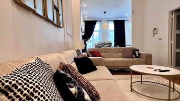 Un salon moderne avec un canapé, une table basse et un tapis à motifs.
