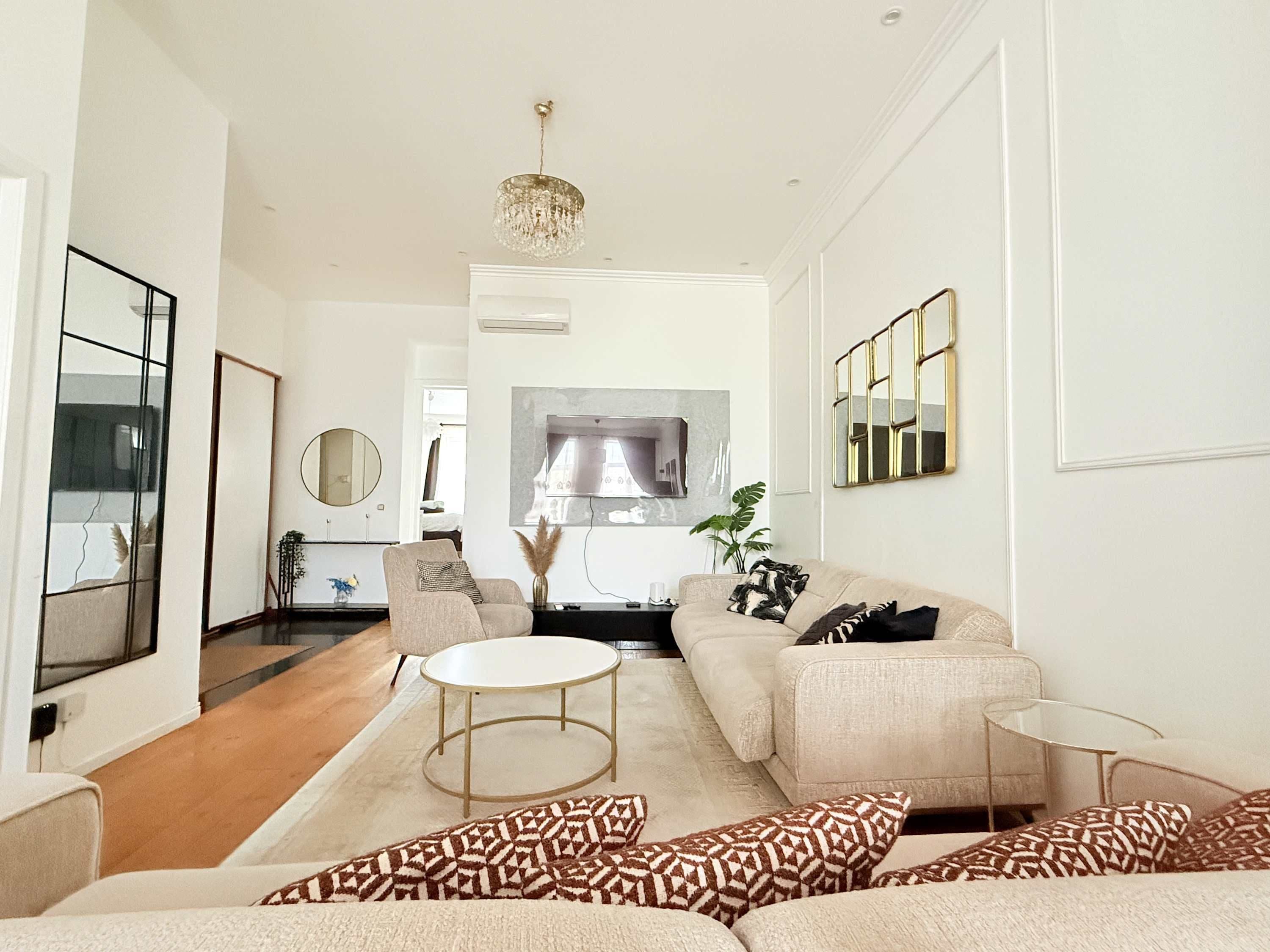 A modern living room with a sofa, a coffee table, and a TV.