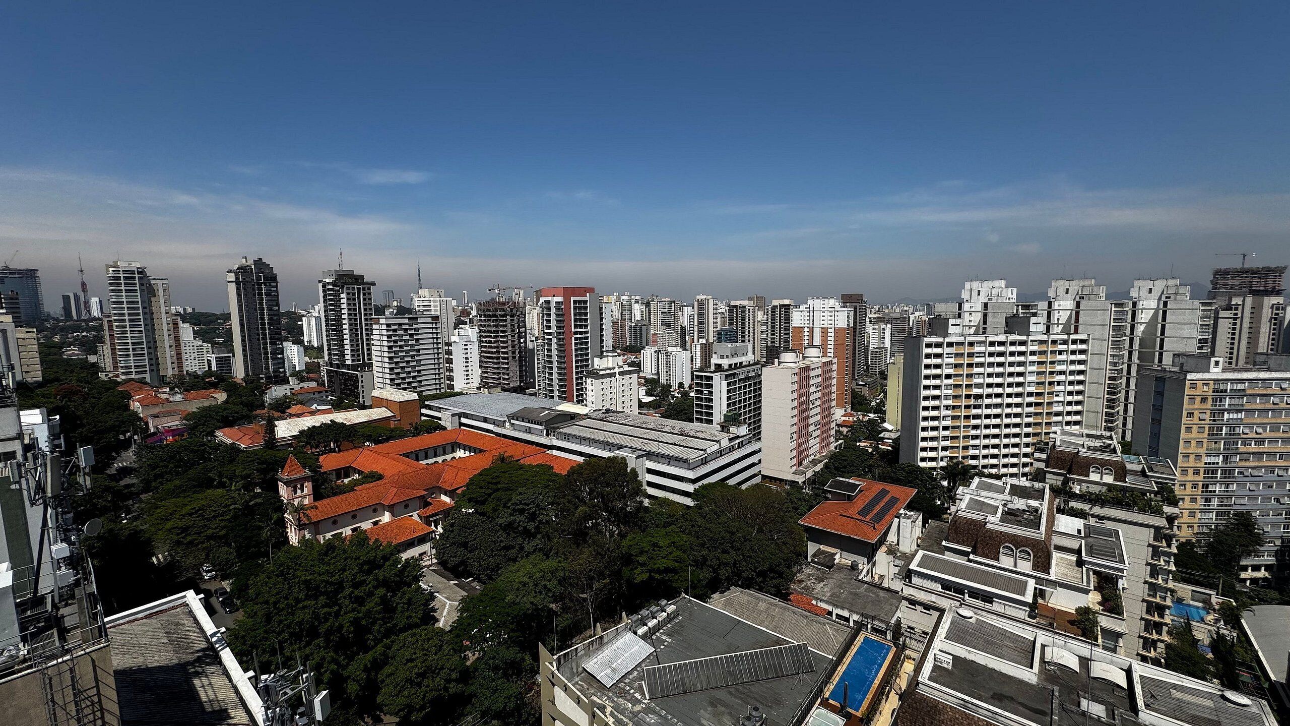 A high-rise urban area with dense skyscrapers, a mix of residential and commercial buildings, and a clear blue sky.