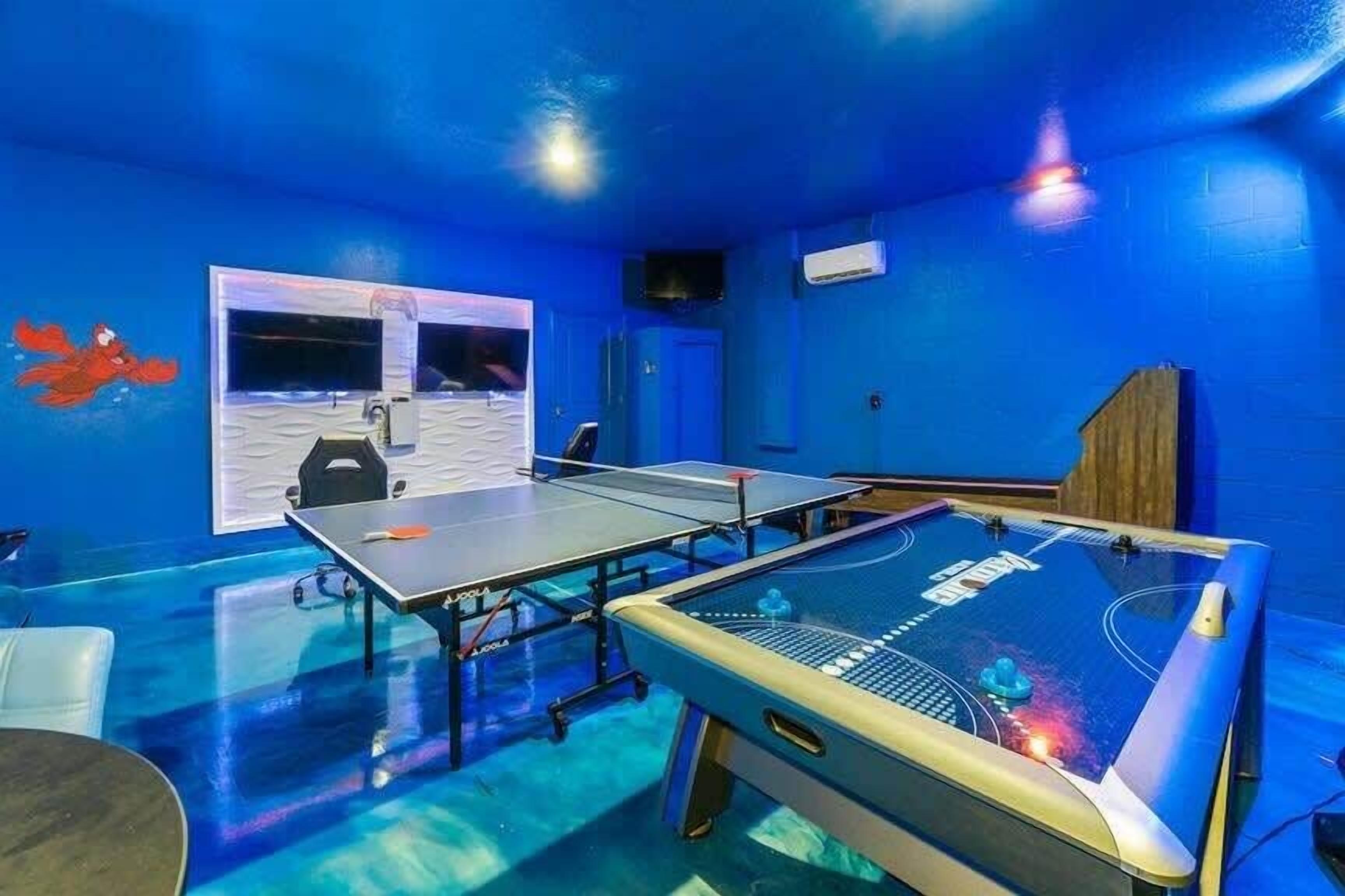 A room with two ping pong tables, a whiteboard, and a blue wall.