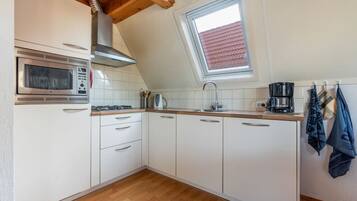 Een koelkast, een microgolfoven, een kookplaat, een vaatwasser