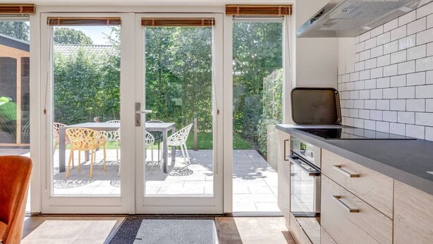 Una cocina moderna con un amplio ventanal corredero que da a un patio exterior.