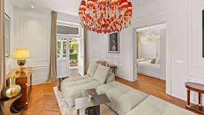 A spacious living room with a large sectional sofa, a chandelier, and a view of the outdoors. - Luxurious home in Opatija with private swimming pool, can be inside or outside (Opatija)