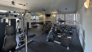 A gym with various exercise equipment, including a bench press, dumbbells, and treadmills. - Luxurious Condo 2BD/2BA w/ Pool, Gym, and Sauna (Scottsdale)