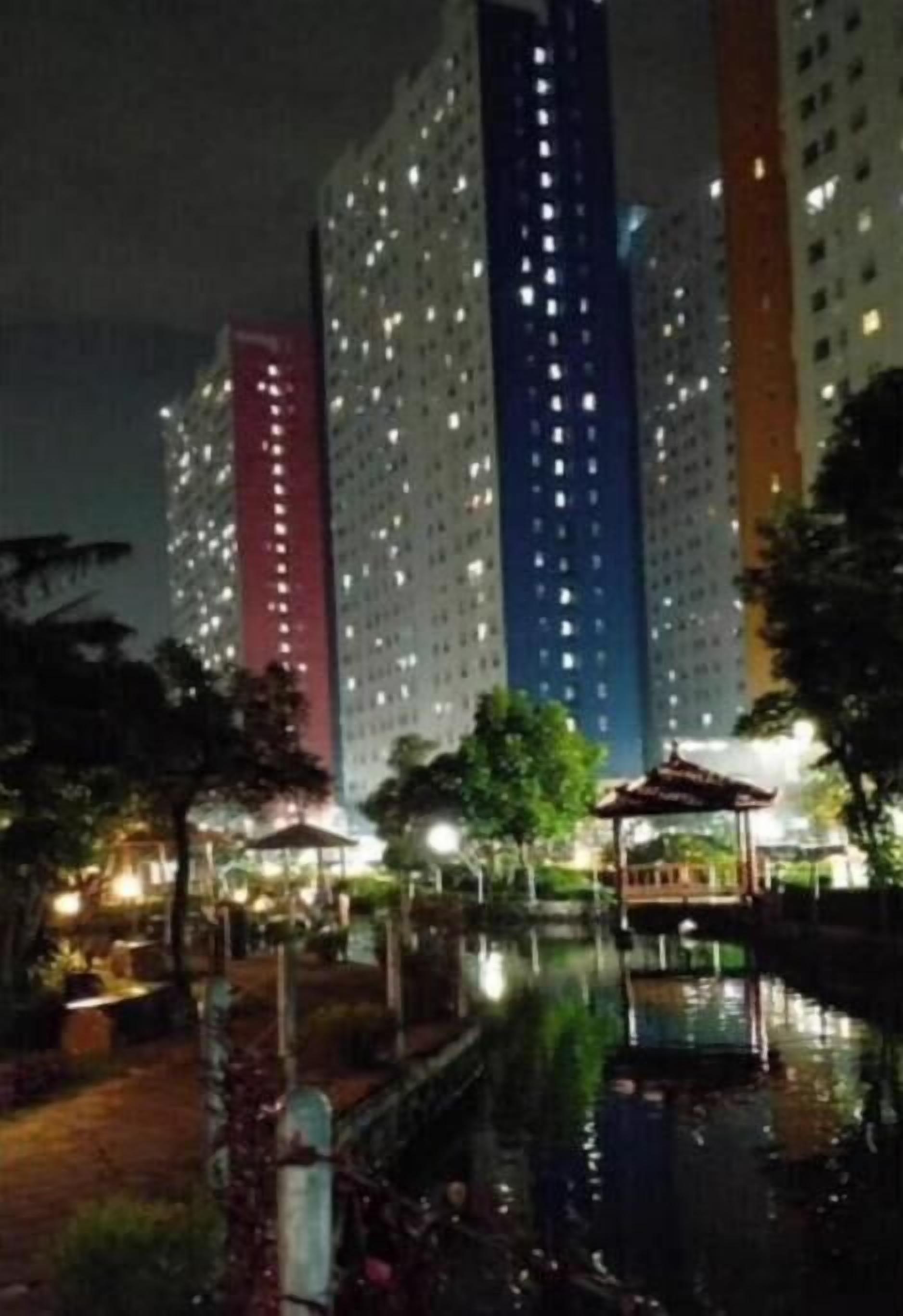 Un immeuble de grande hauteur, doté de nombreux étages, un patio avec un petit étang et un kiosque.
