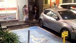 A parking area with a disabled parking sign and a wheelchair symbol. - Cozy Superior Studio at Apartment Green Pramuka City by SHI (Jakarta)