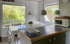 A kitchen with a central island, a microwave, and a dining area with a table and chairs.