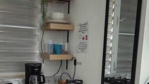 A compact kitchen with a coffee maker, a trash bin, and a mirror. - Studio Apt in Añasco beach 15min drive to Rincon (Añasco)