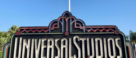 A sign for Universal Studios Hollywood with a clear blue sky in the background.