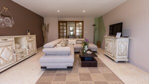 Uma sala de estar moderna com um sofá seccional, uma mesa de centro e dois armários.