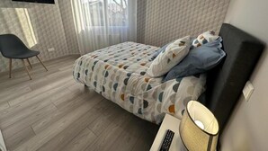 A bedroom with a bed, a chair, a TV, and a lamp. - Gite Montanet - MEES (MEES)