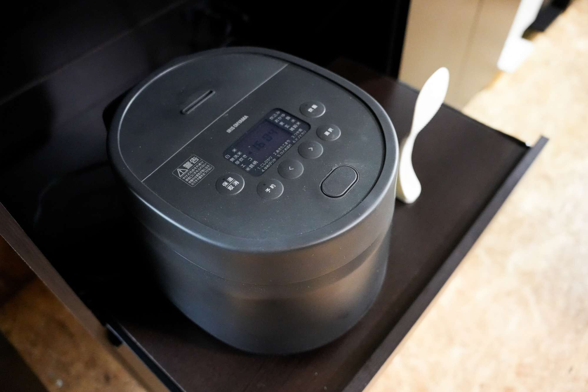 A black appliance with a digital display and several buttons on a black countertop.