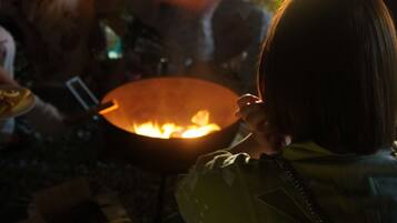 A person cooking over an open flame.