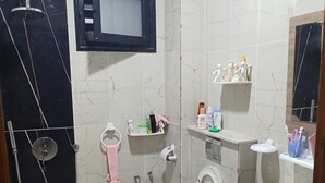 Ein Badezimmer mit Dusche, Toilette, Waschbecken und Spiegel.