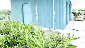 A blue building with two showerheads and a potted plant in the foreground. - Bolongo: Your Exclusive Oceanfront Escape (Sayulita)