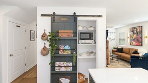 Un salon moderne avec un meuble de rangement coulissant, un canapé, une table basse et un tableau accroché au mur.