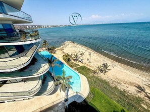 A modern building with a pool, a beach, and a clear view of the sea. - Tizate 3BR Private Beach Stunning View (La Cruz de Huanacaxtle)
