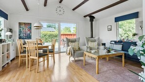 A spacious living room with a wooden dining table and chairs, a glass coffee table, and a blue sofa. - Pet friendly home in Haderslev with WiFi (Haderslev)