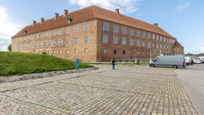 A large, historic brick building with a symmetrical facade and multiple windows.