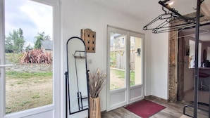 Une pièce spacieuse avec de grandes fenêtres, une porte en bois et un miroir.