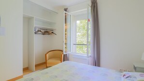 A bedroom with a bed, a chair, a wardrobe, and a window with curtains. - Beautiful home in Monthenault with WiFi (Monthenault)