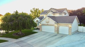 A two-story house with a garage, a driveway, and a well-maintained lawn. - Gorgeous Executive Home (Draper)