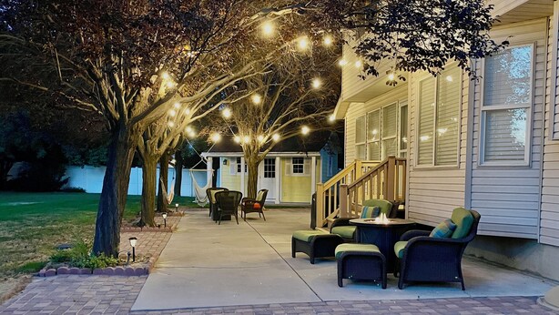 A patio with outdoor furniture and string lights. - Gorgeous Executive Home (Draper)