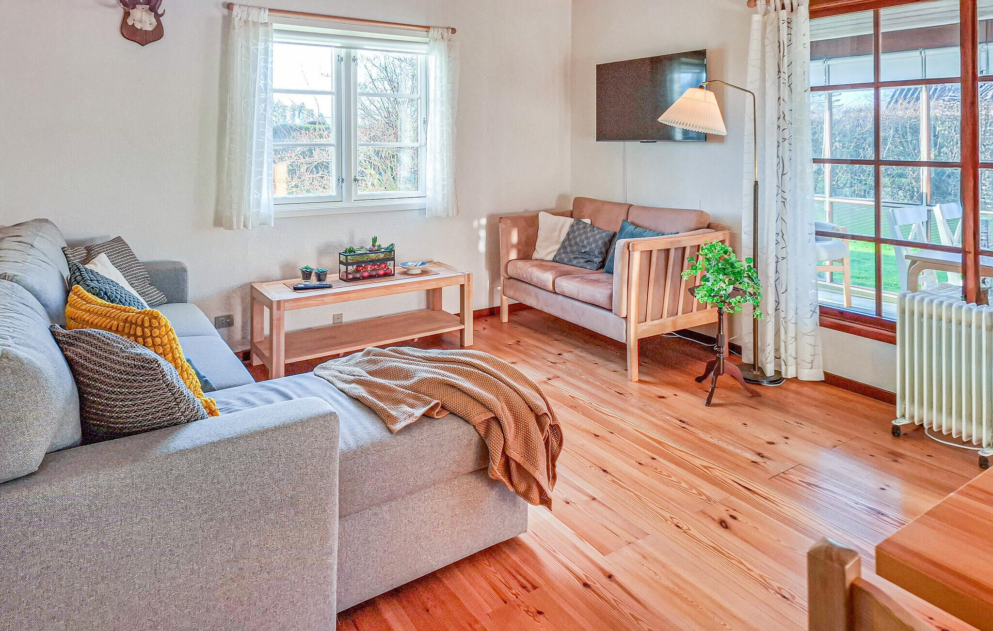 Ein gemütliches Wohnzimmer mit einer Couch, einem Couchtisch und einer kleinen Pflanze.