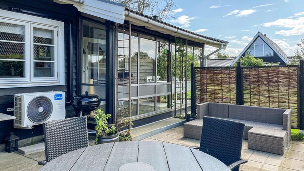 A patio with a table and chairs, a grill, and a fan. - Beautiful home in Otterup with WiFi (Otterup)