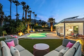 A modern outdoor living area with a pool, seating, and a covered patio. - Kaptur Palms - A Ryson Property (Palm Springs)
