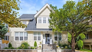 A two-story house with a front porch, a small garden, and a driveway. - Luxury 6BR Beach Home, Sleeps 16  – 1.5 Blks to Beach (Atlantic City)