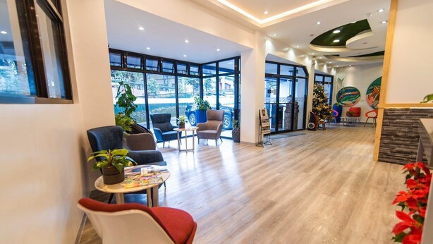 A spacious lobby with modern furniture, large windows, and indoor plants. - Baguio LeFern Hotel (Baguio)