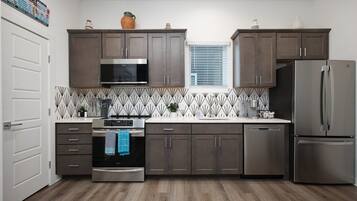 Een magnetron, een oven, een kookplaat, een vaatwasser