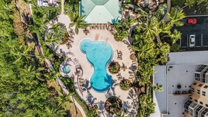 An aerial view of a resort with a central swimming pool, surrounded by palm trees and lounge areas. - Heated Pool, Sauna,| 3BR Condo| Waterside #835 (Fort Myers Beach)
