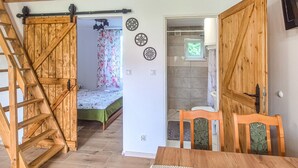 Un intérieur en bois comprenant un lit, une salle de bain et un coin repas.