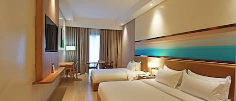 A hotel room with two beds, a desk, a chair, and a large painting on the wall.