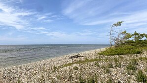 Ein felsiger Strand bei klarem Himmel und ruhigem Wasser.