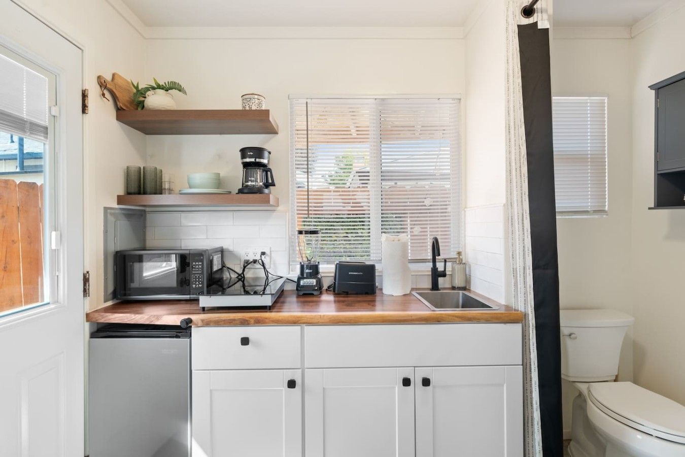 A compact kitchen with a microwave, toaster, and coffee maker.